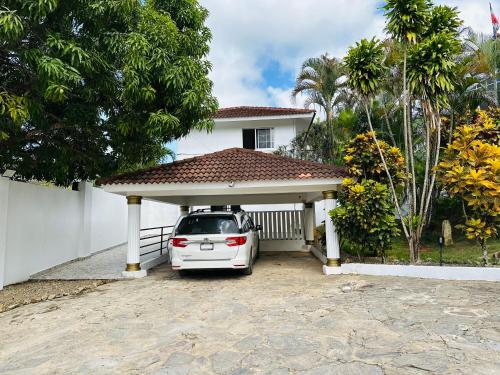 a white car parked in a garage in front of a house at HappiCasaRD & Holistic House in Sosúa