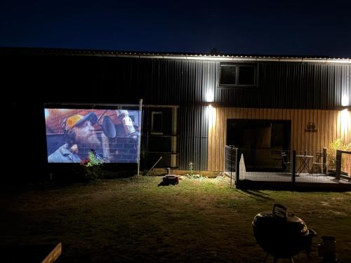 a building with a large screen in the dark at Le Hangar - Studio esprit industriel in Pont-Rémy