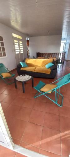 a room with two beds and chairs in it at Belvilla in Le Robert