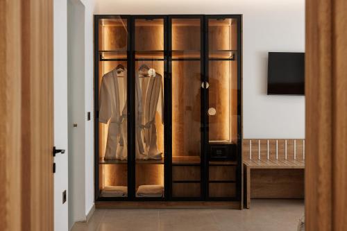 a room with a closet with a shirt and a tv at GkF Luxury Villas in Naxos Chora