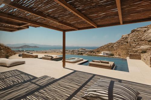 a patio with a swimming pool with a view of the ocean at GkF Luxury Villas in Naxos Chora