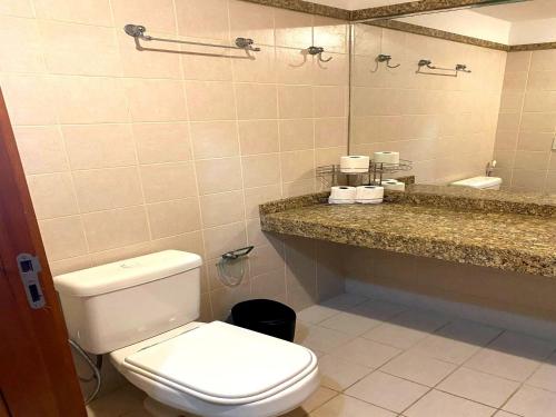 a bathroom with a toilet and a sink and a mirror at Flat Particular Hotel Confort Taguatinga in Taguatinga