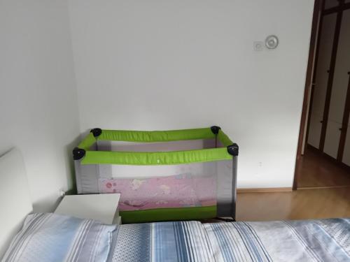 a bed with a green headboard in a room at Stan na dan Miki M in Teslić