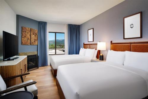 a hotel room with two beds and a television at Martis Valley Lodge, Tapestry Collection by Hilton in Truckee