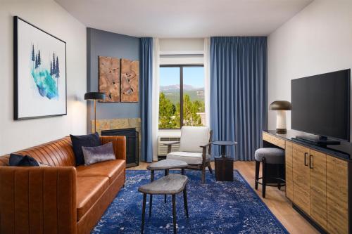 a living room with a couch and a television at Martis Valley Lodge, Tapestry Collection by Hilton in Truckee