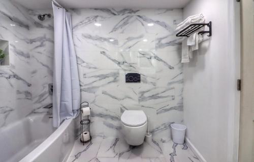 a white bathroom with a toilet and a tub at Luxurious 3 Bedroom, 3 Bathroom, Entire Home in Catskill in Catskill