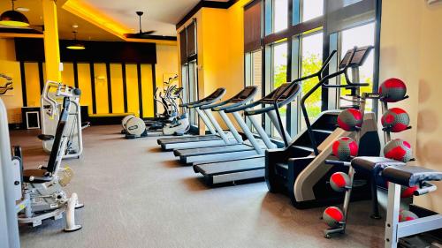 a gym with a row of treadmills and machines at Lux Modern Apartment with Pool View & Prime Location in Frisco