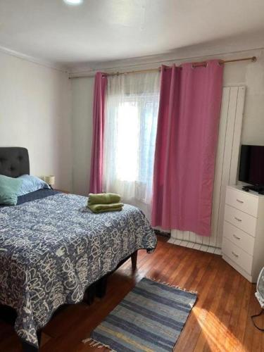 a bedroom with a bed and a window with pink curtains at Hostal Gloria Viña 2 poniente 333 in Viña del Mar