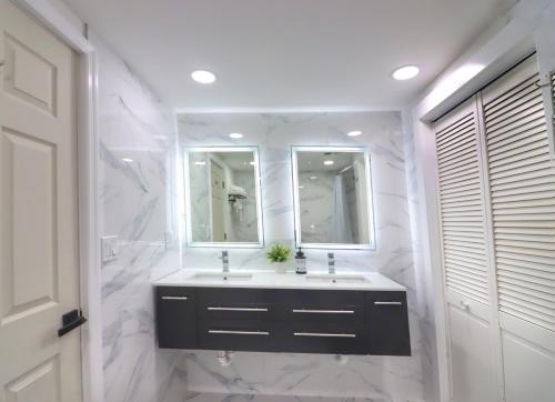 a white bathroom with a sink and two mirrors at Luxurious 3 Bedroom, 3 Bathroom, Entire Home in Catskill in Catskill