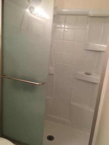 a shower with a glass door in a bathroom at Lake Shores Suites in Shady Shores