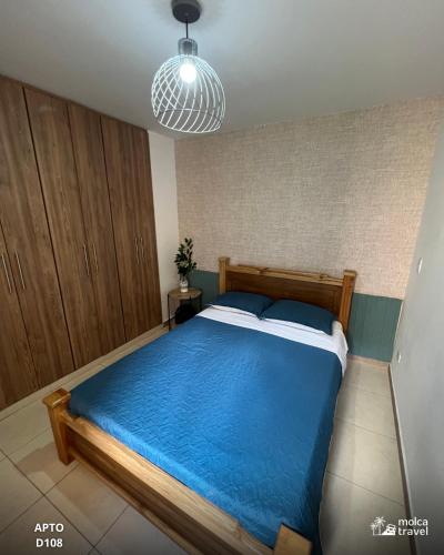 a bedroom with a large bed with a blue blanket at Gran Alojamiento Familiar con 4 Piscinas y Jacuzzi - Para 13 personas - By Molca Travel in Armenia