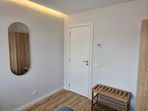 a living room with a mirror and a door at Guimarães Downtown 2 by LuxiStay in Guimarães