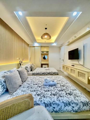 a living room with two beds and a flat screen tv at NAMI Suite Japandi-Inspired 1BR at Azure North in San Fernando