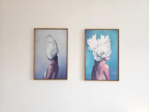 two paintings of women in turbans on a wall at Guimarães Downtown 2 by LuxiStay in Guimarães