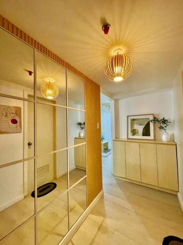 a large room with glass walls and two lights at NAMI Suite Japandi-Inspired 1BR at Azure North in San Fernando