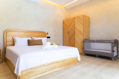 a bedroom with a large white bed and a tv at Villa Privée de Luxe avec Piscine et Vue sur l Atlas Marrakech in Aghmat