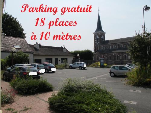 a parking lot with cars parked in front of a building at Loveroom, Les années 80 chez nounours in Templemars