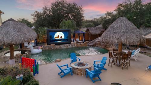 a backyard with a pool with chairs and a tv at Tropical Escape Pool Jacuzzi Bar in Alvin TX in Alvin
