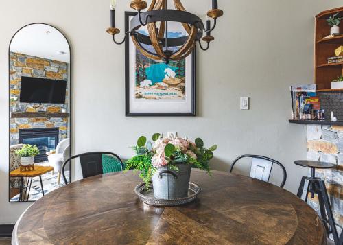 a dining room table with a vase of flowers on it at Alpine Oasis at Alpine Village in Canmore