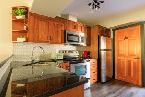 a kitchen with wooden cabinets and a stove top oven at Alpine Oasis at Alpine Village in Canmore