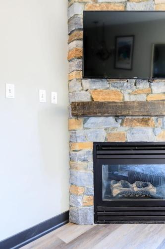 a living room with a fireplace with a flat screen tv at Alpine Oasis at Alpine Village in Canmore