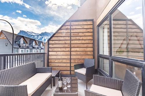 a balcony with chairs and tables on a building at Alpine Oasis at Alpine Village in Canmore