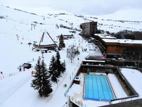 a ski resort with a swimming pool in the snow at Résidence Phenix - RESIDENCE PHENIX STUDIO POUR 4 PERSONNES MAE-9884 in Le Corbier