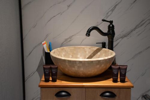 a bathroom with a bowl sink on a wooden cabinet at Dragon Glamping in Luže