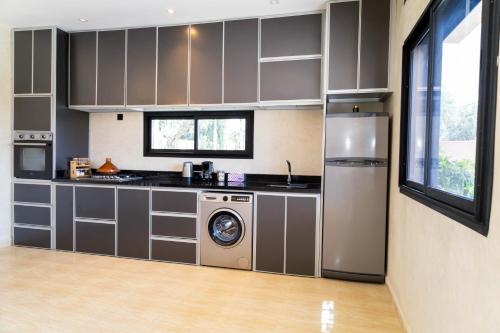 a kitchen with a washer and dryer in it at Villa Privée de Luxe avec Piscine et Vue sur l Atlas Marrakech in Aghmat