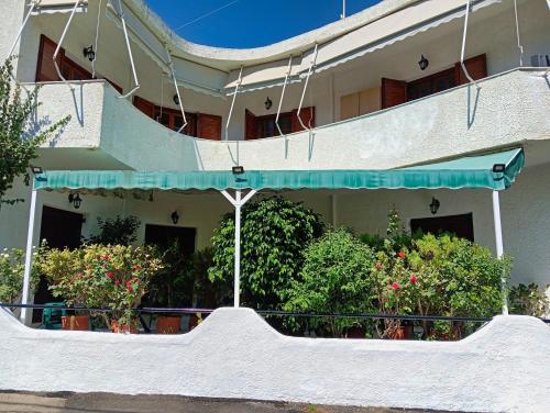 a building with a balcony with flowers and plants at Akrata Golden Beach House in Aíyira
