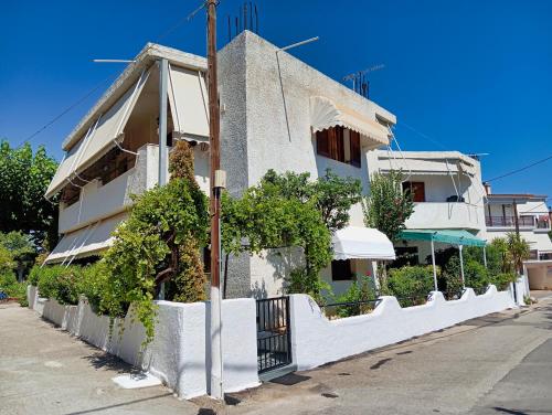 a white building with plants on the side of it at Akrata Golden Beach House in Aíyira