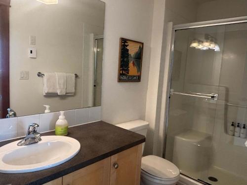 a bathroom with a sink and a shower and a toilet at Alpine Vista - Family Fun Pool & Hot Tub in Canmore