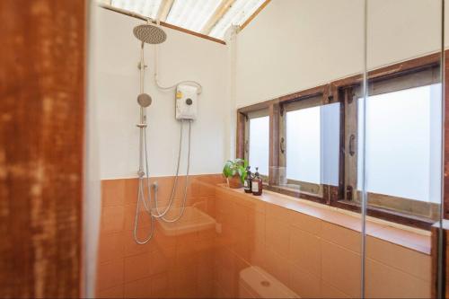 a bathroom with a shower with a glass door at Mana Craft Stay in Bangkok