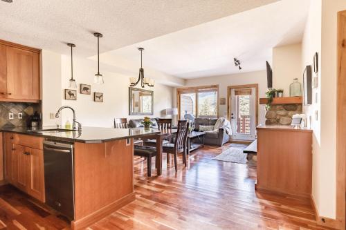 a kitchen and living room with a table and chairs at Creekside at Rundle Cliffs Lodge in Canmore