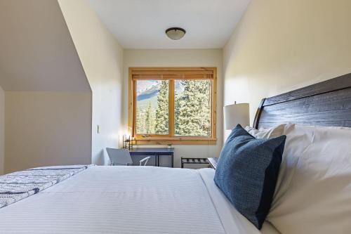 a bedroom with a large bed and a window at Creekside at Rundle Cliffs Lodge in Canmore