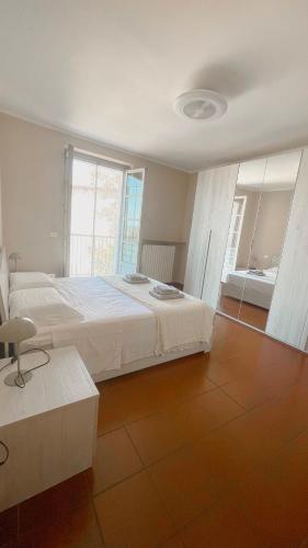 a bedroom with a large white bed and a window at Ampio appartamento centro storico - Famiglie in Montalto Pavese