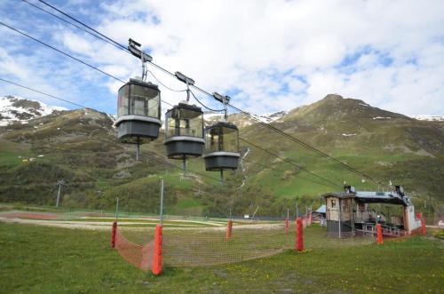 a ski lift with chairs on it in the mountains at Résidence Villaret - Grand studio coin chambre séparé cuisine équipée aux Ménuires MAE-5274 in Les Menuires