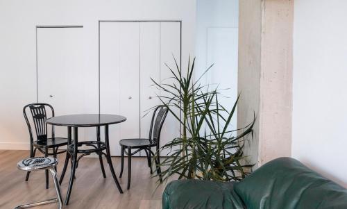 a table and chairs in a living room with a plant at Stuning penthouse old montreal in Montréal