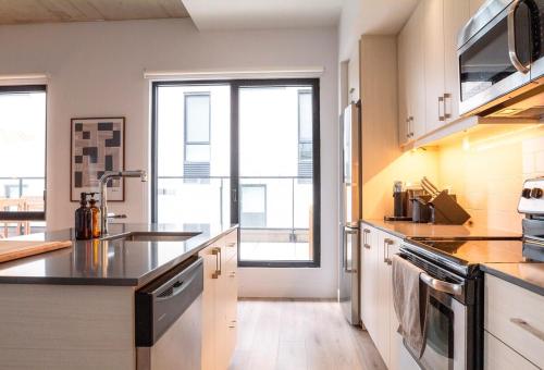a kitchen with stainless steel appliances and a large window at Stuning penthouse old montreal in Montréal
