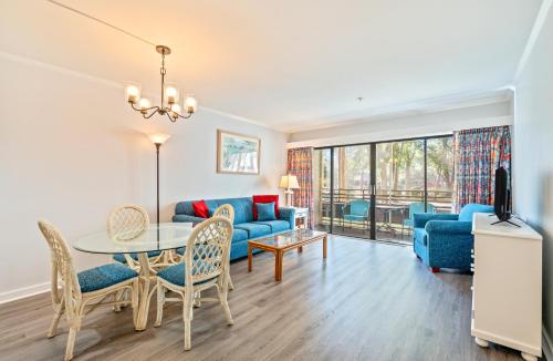 a living room with a blue couch and a table at Ocean Creek Resort in Myrtle Beach