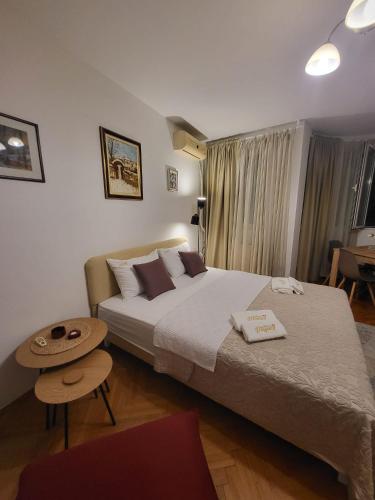 a hotel room with two beds and a table at Apartmani Dragulji Krusevac in Kruševac