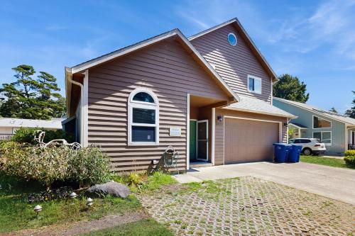 a house with a garage in front of it at Once Upon a Tide in Lincoln City
