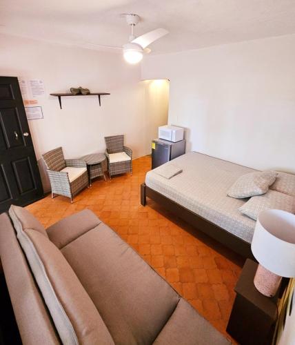 a large bedroom with a bed and a couch at Casa Pura Vida Surf Hostel - Tamarindo Costa Rica in Tamarindo