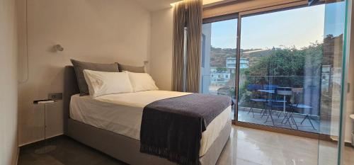 a bedroom with a bed and a large window at SeaNest Bali in Bali