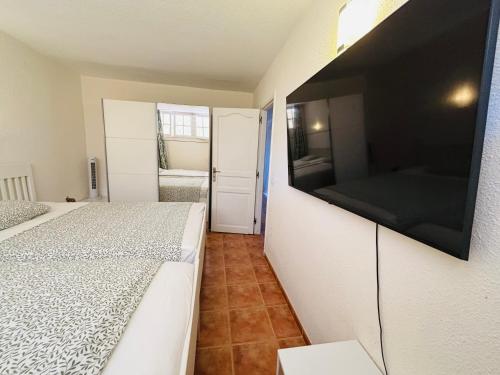a bedroom with two beds and a flat screen tv at Neptuno Beachfront Retreat with smart TVs and Terrace in Puerto de Santiago