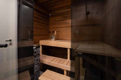 a bathroom with a shower with wooden walls and a table at Rovaniemi City Apartments in Rovaniemi