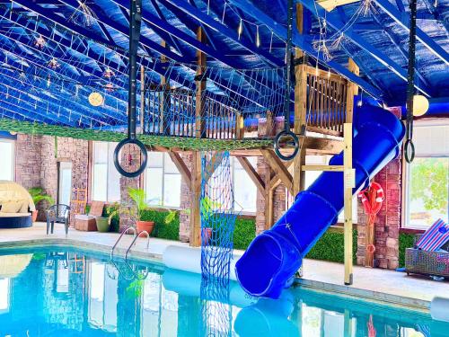 a swimming pool with a slide in a building at The Yurt at Paradise Pointe with a hot tub fire pit & Grill in Bryant
