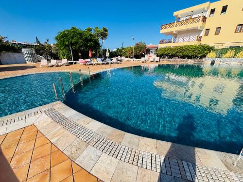a large swimming pool in front of a building at Neptuno Beachfront Retreat with smart TVs and Terrace in Puerto de Santiago