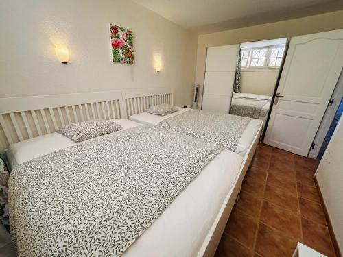 a bedroom with two beds and a window at Neptuno Beachfront Retreat with smart TVs and Terrace in Puerto de Santiago