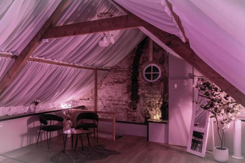 a room with a purple ceiling and a table with chairs at Guesthouse Looierij de Luxe - privé wellness in Dongen